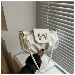 Détail du sac sous l'aisselle plissé blanc avec boucle nœud argenté et anse tressée