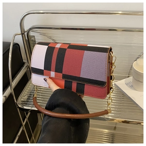 Close-up of red and black plaid underarm bag with gold chain and leather handle