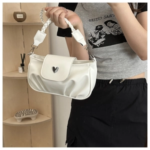 Detailed close-up of milk white pleated shoulder bag with heart-shaped metal buckle