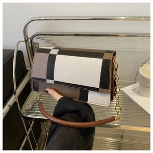 Detail of vintage geometric plaid crossbody bag with chain strap and round top handle