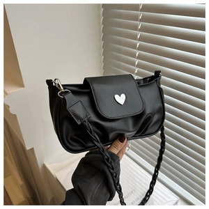 Detail of black pleated bag with silver heart lock and braided shoulder strap