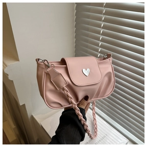 Detail of pink pleated handbag with heart buckle and braided shoulder strap