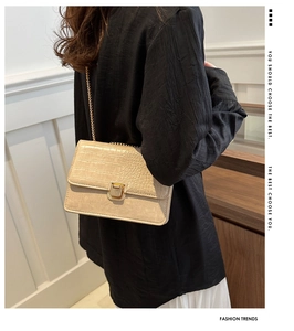 Détail du sac à main beige motif crocodile avec chaîne dorée et fermoir métallique