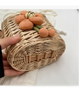 Detail of hand-woven straw bag featuring orange fabric flowers and textured finish