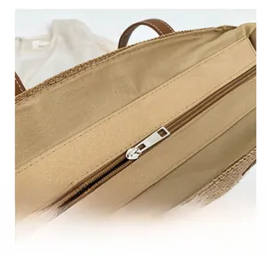 Detailed top view of the woven tote bag featuring a smooth metal zipper and canvas lining