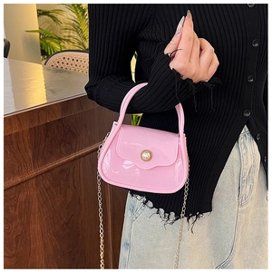 Detail of pink jelly handbag featuring pearl buckle and golden chain strap for women