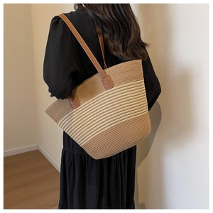 Detail of contrast woven tote bag with brown leather straps shown on model shoulder