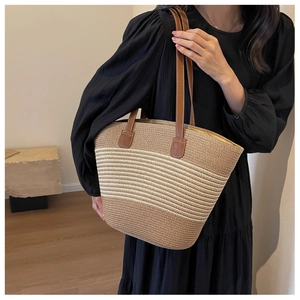 Detail of hand-woven tote bag with leather shoulder straps and color-block striped pattern