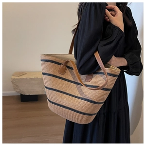 Contrast woven straw tote bag with navy stripes and brown leather straps for summer beach