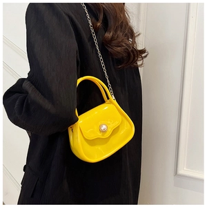 Detail of yellow waterproof PVC mini bag with pearl buckle and golden chain strap