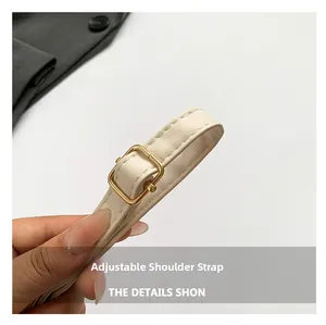 Close-up of beige shoulder bag adjustable strap with premium gold metal buckle