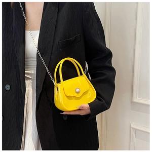 Close-up of yellow mini PVC jelly bag with pearl buckle and metal chain strap
