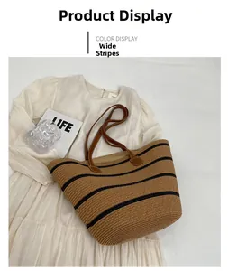 Close-up of wide black stripes on woven straw tote bag with leather handles