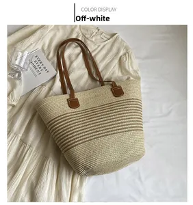Detailed close-up of woven cream tote bag with brown leather straps for beach holiday