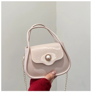 Close-up of mini PVC jelly bag in light pink with a pearl buckle and golden chain