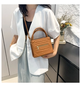 Brown crocodile embossed handbag styled with a white blazer for a modern fashion look