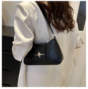 Chic black shoulder bag featuring a silver star buckle shown on a model's shoulder