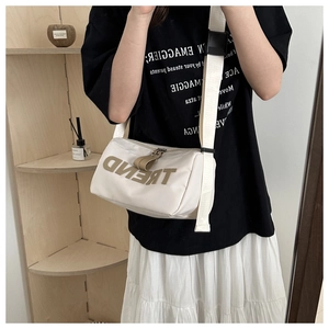 Detail of off-white nylon pillow bag with TREND patch and adjustable wide strap