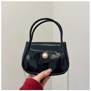 Detailed close-up of a black glossy mini bag with a pearl buckle and golden chain