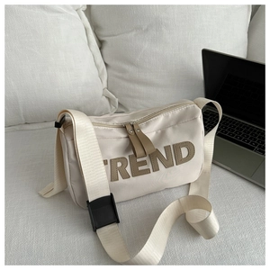 Detail of cream Oxford tote with brown TREND patch and wide adjustable nylon shoulder strap