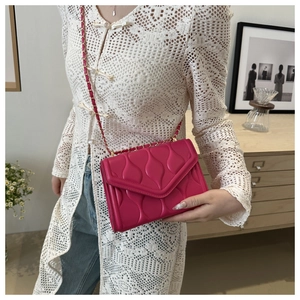 Dettaglio della borsa trapuntata rosa con elegante tracolla a catena dorata