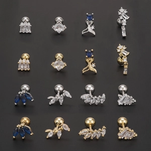 Blue zircon ear bone studs set in silver and gold plating with geometric designs