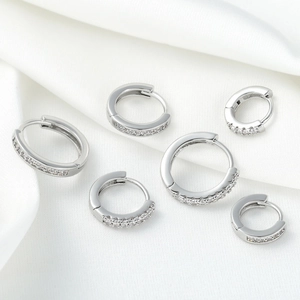 Ensemble de créoles en argent avec zircone cubique sur soie blanche élégante