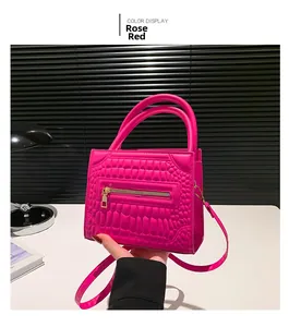 Detail of crocodile embossed rose pink tote bag with front zipper and top handles
