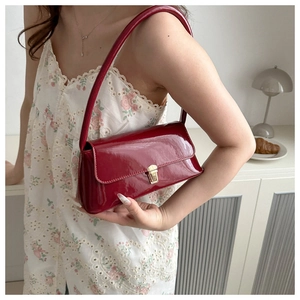 Mannequin portant un sac baguette bordeaux en cuir verni avec fermoir doré