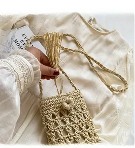 Détail d'un sac en paille tissé avec texture faite main, franges et fermeture bouton