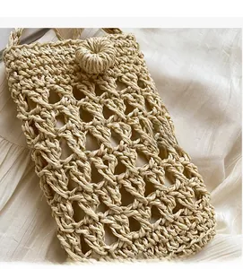 Détail du sac bohème en paille tressée avec texture ajourée et fermoir à bouton boule