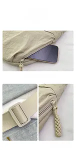 Detail of beige nylon crossbody bag featuring wide strap and hidden zipper compartment