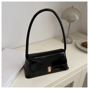 Chic black patent leather baguette shoulder bag with gold clasp in minimalist setting