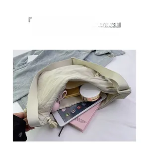 Interior layout of large beige nylon dumpling bag showing storage space for tablet and books