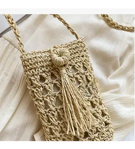 Gros plan détaillé du sac en paille tressée ajouré avec glands décoratifs et texture
