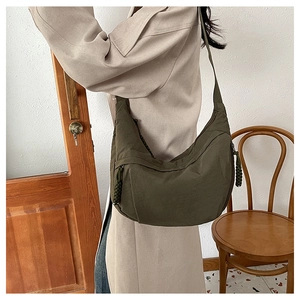 Detailed view of an olive green nylon dumpling bag with multiple zipper compartments