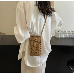 Petit sac bandoulière en paille tressée ajourée avec pompon pour femme porté