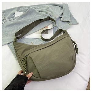Close-up of olive green nylon hobo bag with wide strap and woven zipper puller