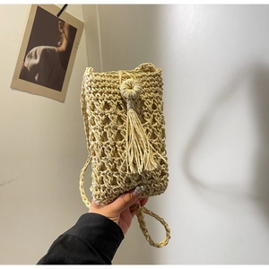 Détail du sac de téléphone tissé à la main avec pompon décoratif et bouton rond