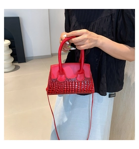 Detail of red croc-embossed leather tote with top handle and detachable strap