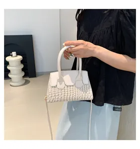 Close-up of cream crocodile pattern handbag showing material texture and shoulder strap