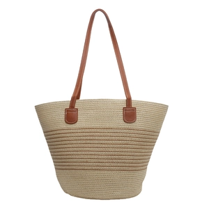 Contrasting woven tote bag with brown leather handles and beige straw texture