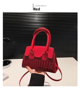 Detail of red small square crossbody bag featuring crocodile pattern leather texture
