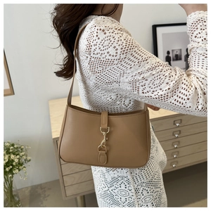 Minimalist khaki leather underarm bag with gold buckle closure in home setting