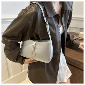 Silver metallic leather shoulder bag with gold clasp shown on a fashion model