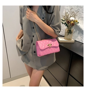 Detailed view of pink quilted crossbody bag with gold chain strap and metal triangle clasp