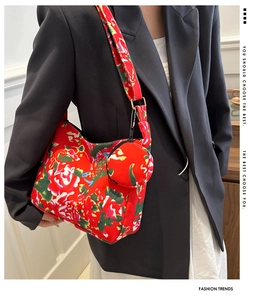 Red floral print crossbody bag with matching circular coin pouch shown on a model outfit