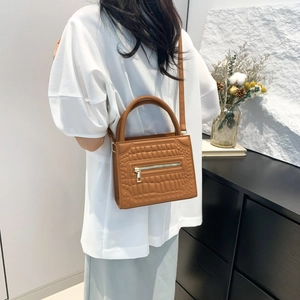 Brown crocodile embossed handbag for women with a gold zipper and crossbody strap