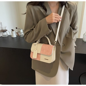 Detail of a color-block small square bag with ivory and dusty pink textured faux leather