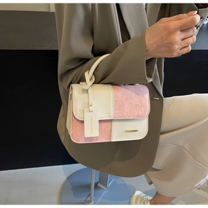 Detail of color-block flap bag with knot handle and texture stitching close-up